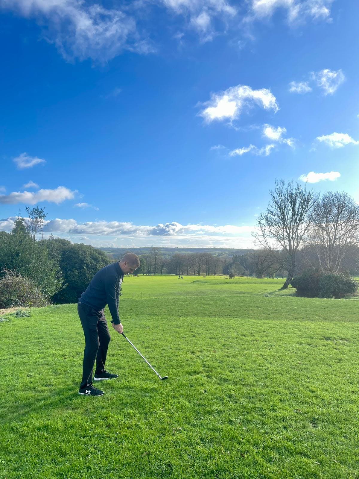 Golfer teeing off on the Welbeck Manor course with scenic Devon countryside views