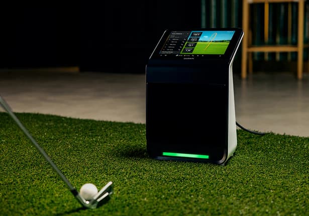 Garmin Approach R50 launch monitor on artificial turf with golf club and ball